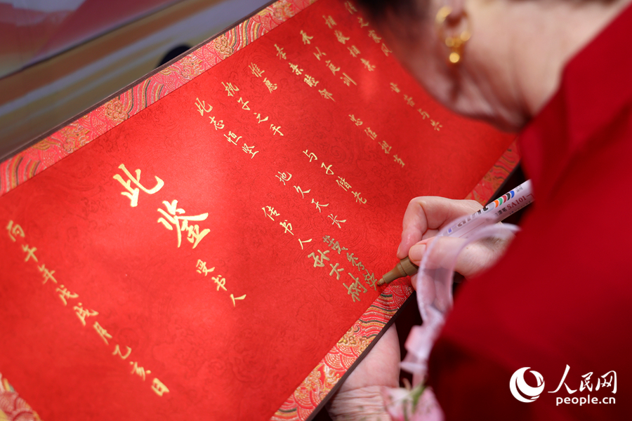 金婚夫婦代表在卷軸上簽名。人民網記者 陳博攝