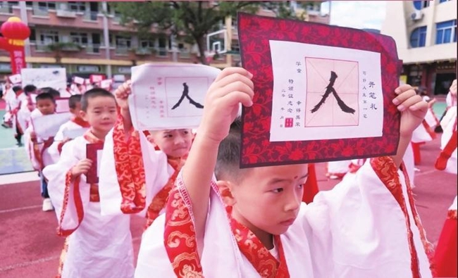 学子展示所写的“人”字（兰景赟 摄）