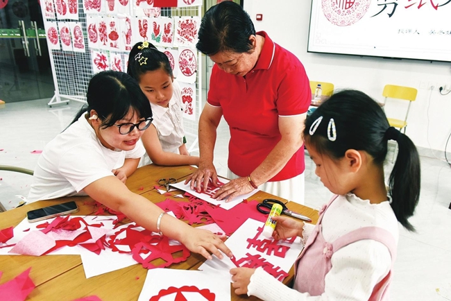 学生和家长共同剪纸（罗 姮 摄）