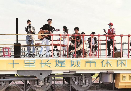 在挖掘自然景观资源和提升配套设施水平基础上，集美区让游客在“十里长堤”游玩中尽览自然之美与人文之美。图为艺人演出现场。天下集美供图