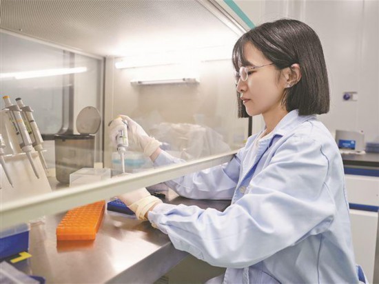 在致善生物，党员带头打造“冠军产品”。图为致善生物的党员在PCR配液间内配制溶液。记者 卢剑豪摄